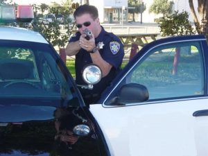 Police officer with gun drawn